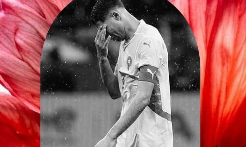 ​صورة باللونين الأبيض والأسود للاعب أشرف حكيمي بقميص المنتخب المغربي يضع يده على وجهه في لحظة تأثر وحزن بعد خسارة لقب كأس أمم إفريقيا 2025.