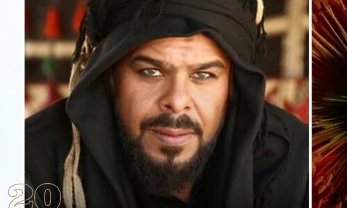 الفنان منذر رياحنة يرتدي ملابس تاريخية بدوية بعباءة سوداء وغطاء رأس، يجسد شخصية الشاعر الشنفرى في مسلسل أبطال الرمال، مع خلفية تحمل شعار مجلة هرة وعام 2026.